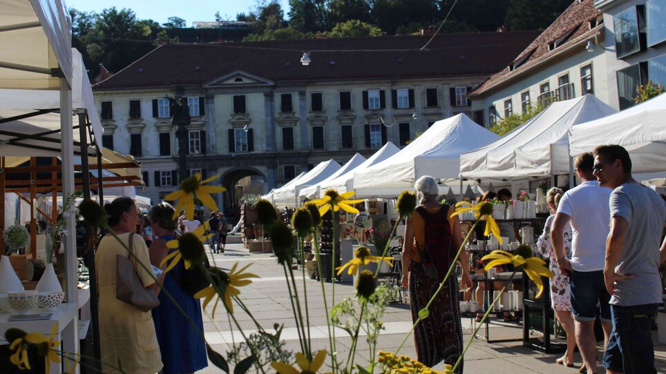 Vista del mercato della ceramica con stand e fiori gialli.