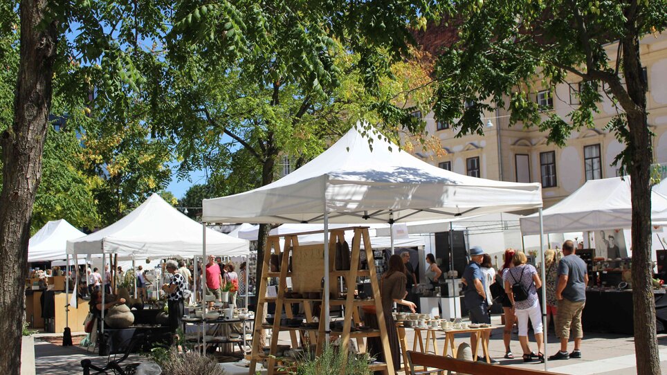 I visitatori passeggiano per il mercato della ceramica con numerosi stand.