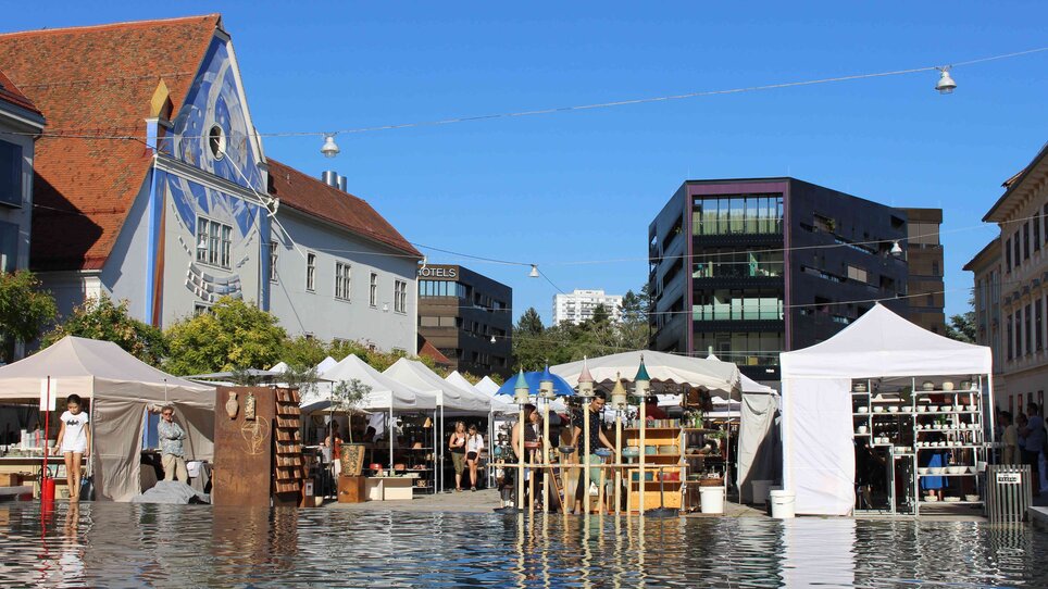 Vista del mercato della ceramica con stand e cielo blu a Graz.