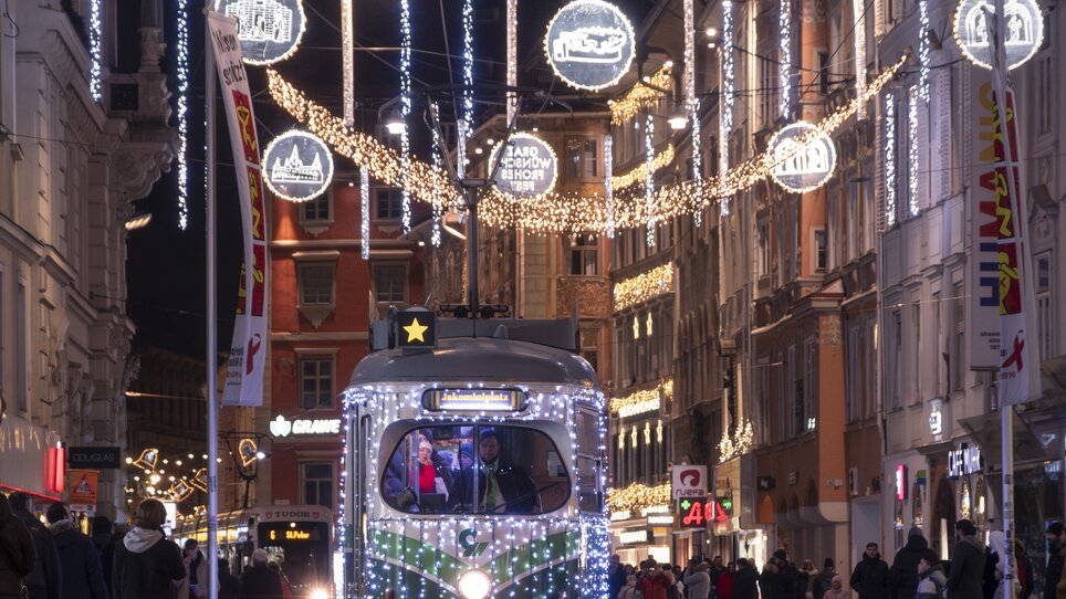 Illuminated streets with tram in Graz, decorated for Christmas. | © Vincent Croce
