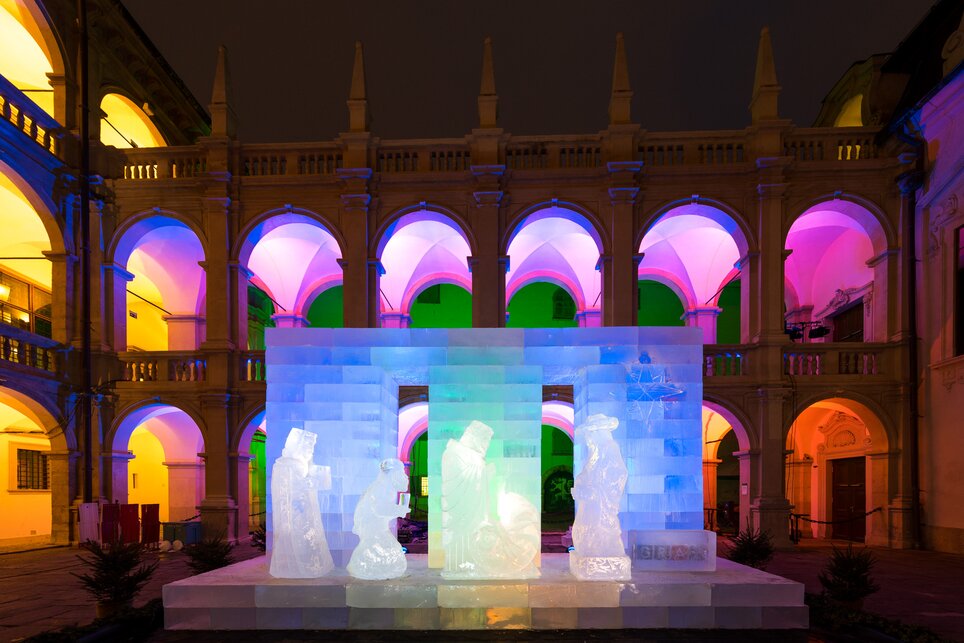 Ice sculpture of a nativity scene in the Landhaus courtyard, illuminated by colorful lights. | © Graz Tourismus - Harry Schiffer