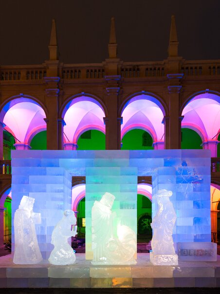 Eiskunstwerk einer Krippe im Landhaushof, beleuchtet von bunten Lichtern. | © Graz Tourismus - Harry Schiffer