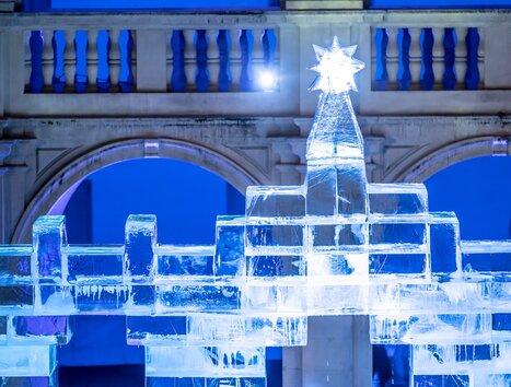 An artistic ice nativity scene with a Christmas star in the Landhaus courtyard in Graz, illuminated by blue lights. | © Stadt Graz - Foto Fischer
