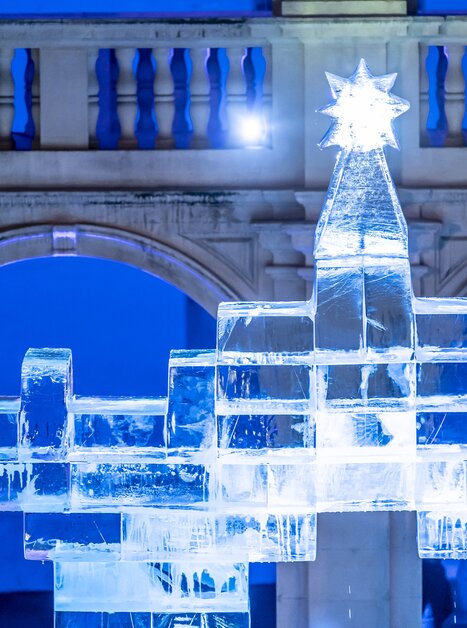 Eine kunstvolle Eiskrippe mit Weihnachtsstern im Landhaushof in Graz, beleuchtet von blauen Lichtern. | © Stadt Graz - Foto Fischer