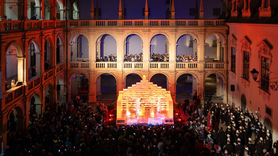 A bustling scene with an ice nativity in the Landhaus courtyard, surrounded by spectators and festive lighting. | © Region Graz - Harry Schiffer