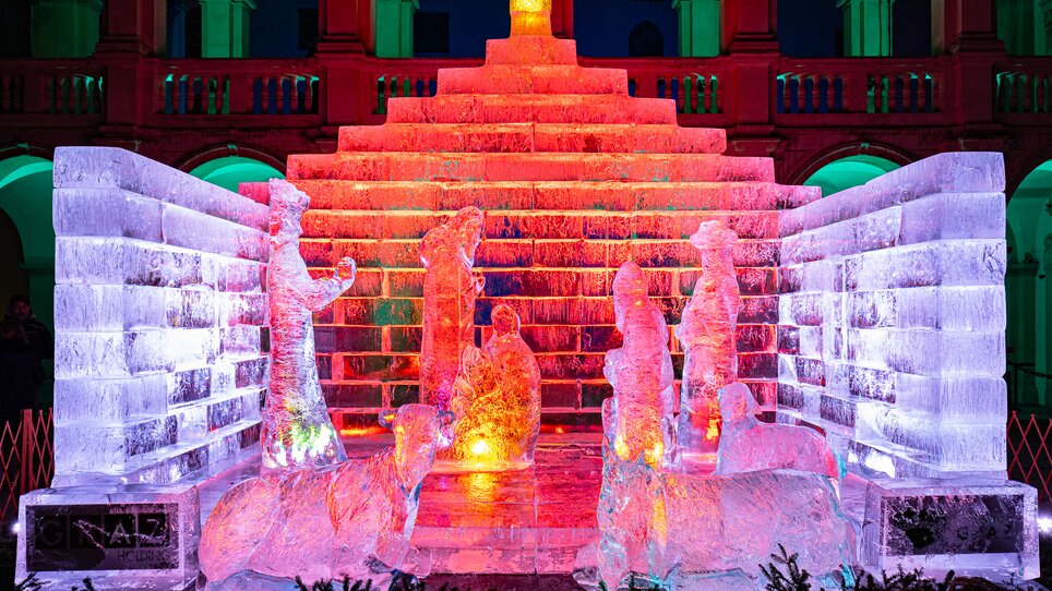 Ice nativity scene in the Landhaus courtyard illuminated with colorful lights. | © Region Graz - Harry Schiffer