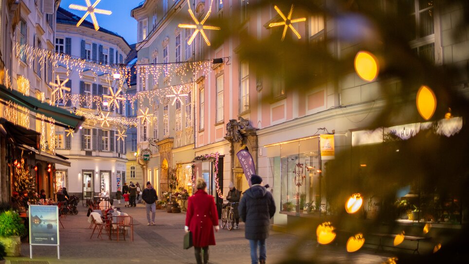 Weihnachtlich dekorierte Stempfergasse in Graz mit Lichtern und Besuchern. | © Graz Tourismus - Harry Schiffer