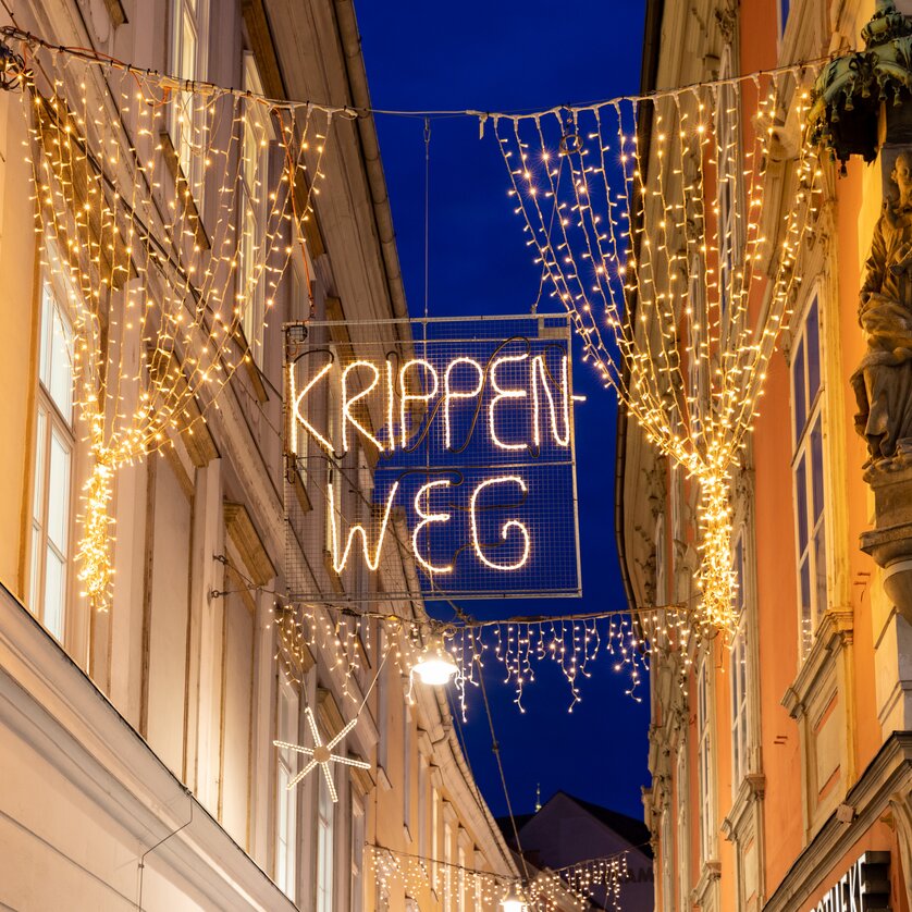 Advent in Graz I Krippenweg in der Stempfergasse | © Graz Tourismus-Harry Schiffer Beleuchtete und weihnachtlich dekorierte Stempfergasse mit dem Schriftzug Krippenweg. | © Graz Tourismus-Harry Schiffer