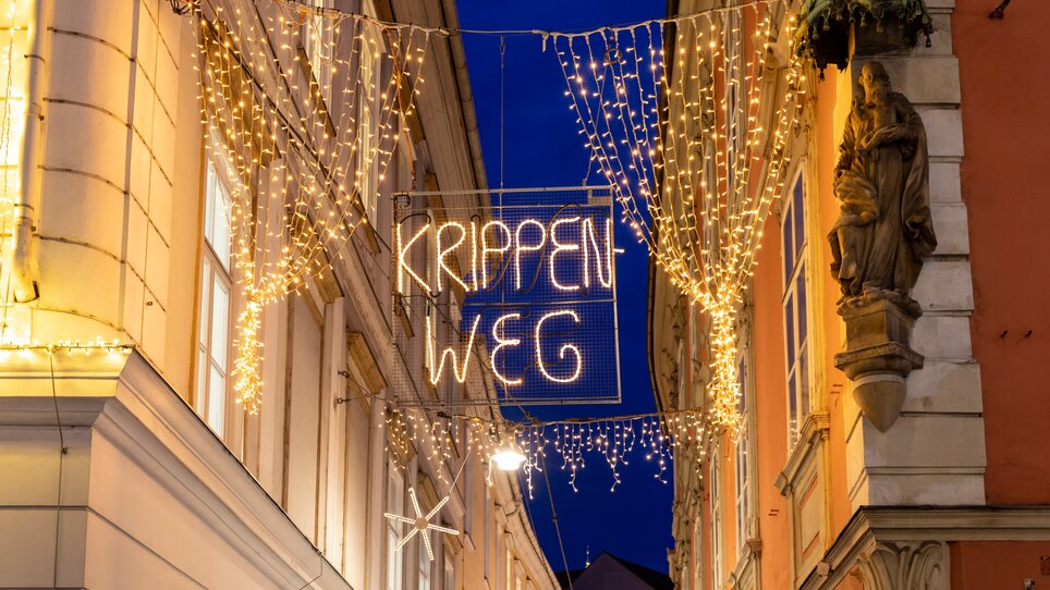 Beleuchtete und weihnachtlich dekorierte Stempfergasse mit dem Schriftzug Krippenweg. | © Graz Tourismus-Harry Schiffer
