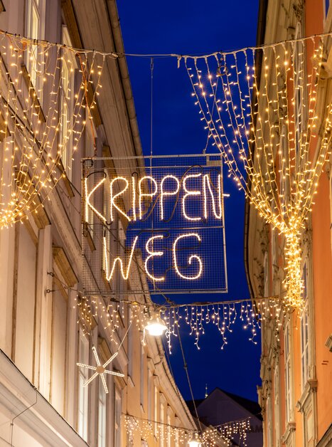 Illuminated Christmas decorated Stempfergasse with the sign Krippenweg. | © Graz Tourismus-Harry Schiffer