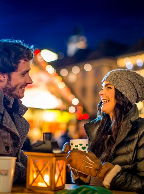 Paar genießt Getränke in Graz mit festlicher Beleuchtung. | © Graz Tourismus - Tom Lamm