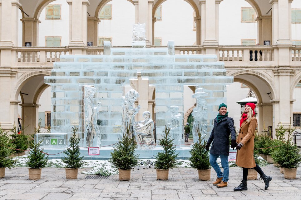 Ein Paar spaziert vor einer imposanten Eisskulptur in Graz. | © Graz Tourismus - Mias Photoart
