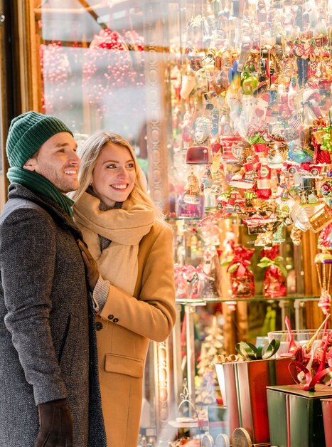 Ein Paar bewundert festliche Weihnachtsdekorationen in einem Schaufenster. | © Graz Tourismus - Mias Photoart