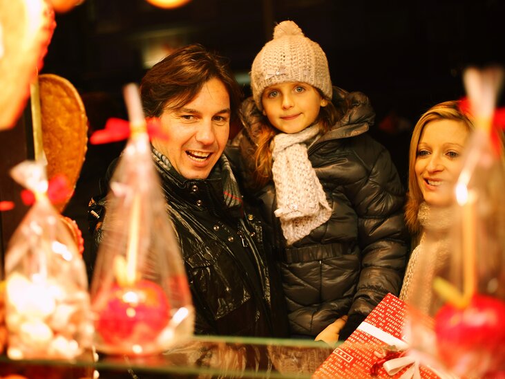 Eine Familie vor einem Marktstand voller Süßigkeiten und Leckereien. | © Graz Tourismus - Max Wegscheidler