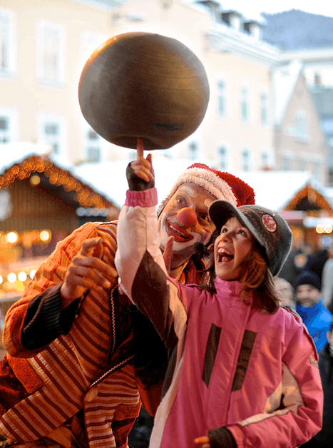 A clown and a girl together spin a plate at a Christmas market in Graz. | © Foto Jakotopia