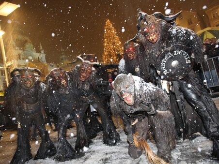 Gruppe von Perchten in Festkleidung bei Nacht in Graz, im Schnee. | © Graz Tourismus - Harry Schiffer