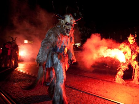 Krampus- und Perchtenläufer in der Dunkelheit, umgeben von Rauch. | © Graz Tourismus - Harry Schiffer