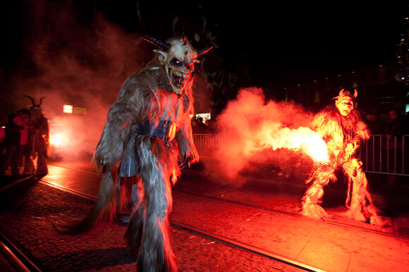 Figure di Krampus e Perchten nel buio, circondate da fumo. | © Graz Tourismus - Harry Schiffer