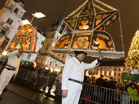 Persone in abiti bianchi portano lanterne elaborate durante la sfilata del Krampus e Perchten a Graz, circondate da spettatori e luci festose. | © Graz Tourismus - Harry Schiffer