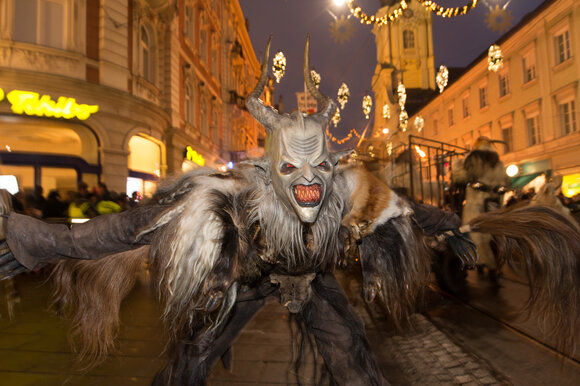 Un Krampus con un volto inquietante e vestiti pelosi danza per la strada a Graz. | © Graz Tourismus - Harry Schiffer
