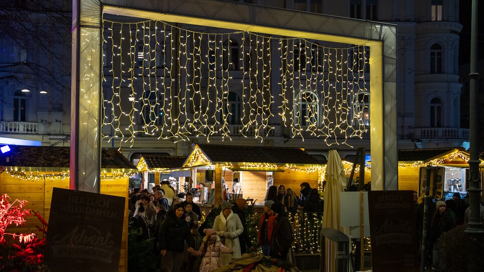 Mercato di Natale a Graz con luci e persone. | © Peter Hutter