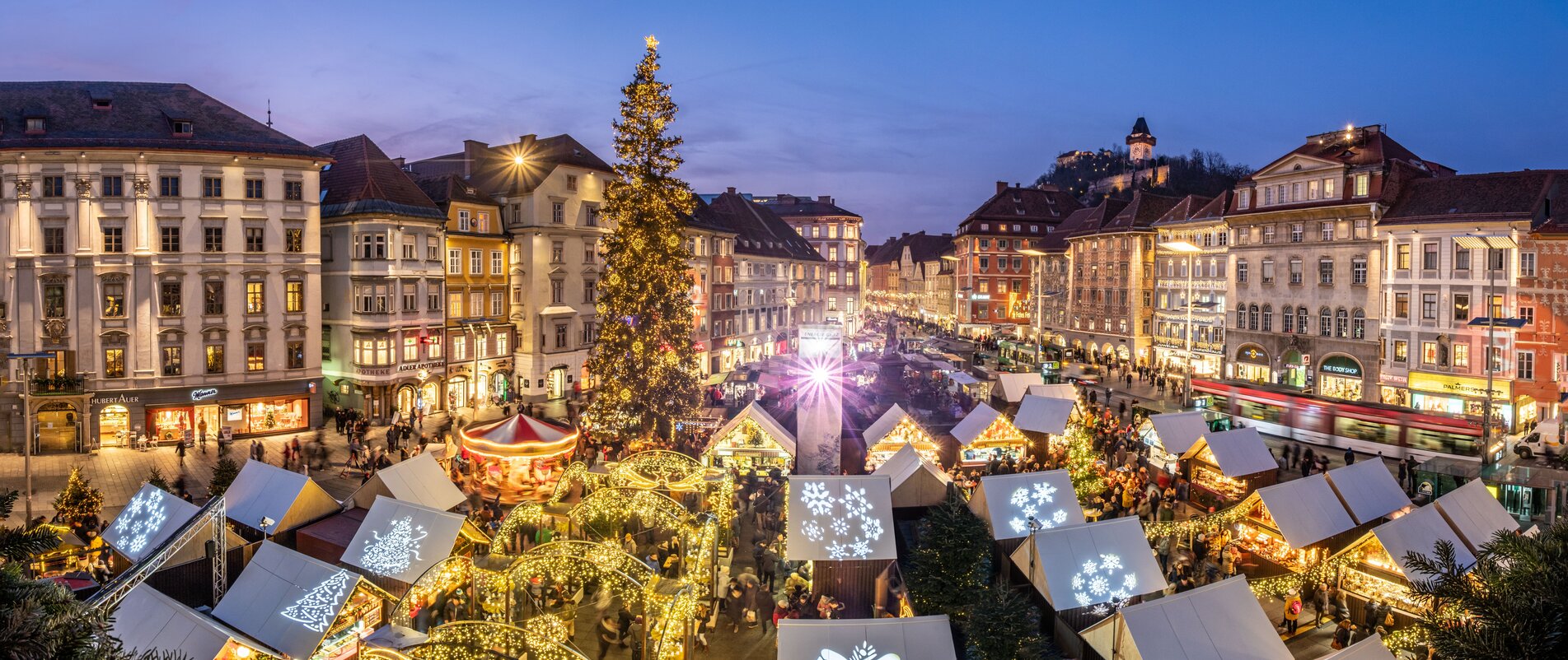 Advent in Graz I Christkindlmarkt vor dem Rathaus am Hauptplatz | © Graz Tourismus - Rene Walter Weihnachtsmarkt in Graz mit festlich beleuchteten Ständen und großer Tanne. | © Graz Tourismus - Rene Walter