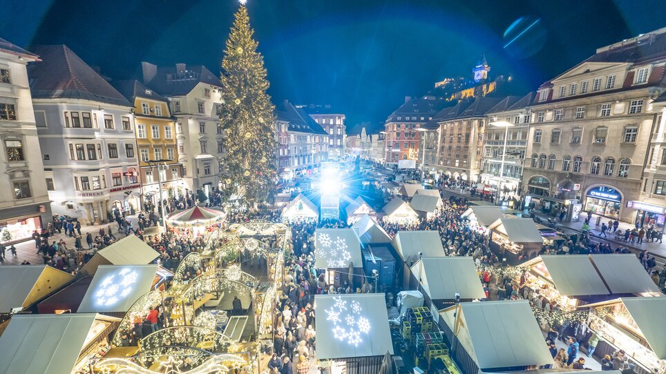 Weihnachtsmarkt in Graz mit festlich beleuchtetem Baum und Ständen am Hauptplatz. | © Stadt Graz Foto Fischer