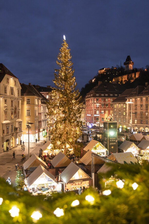 Weihnachtsmarkt in Graz mit geschmücktem Baum und festlicher Beleuchtung. | © Vincent Croce
