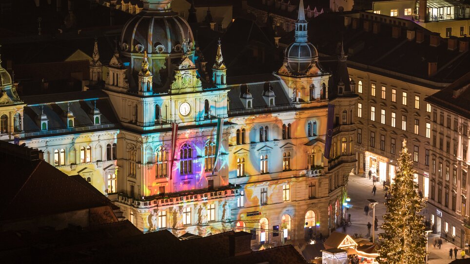 Illuminated town hall in Graz at the Christmas market with colorful lights and decorations. | © Graz Tourismus - Harry Schiffer