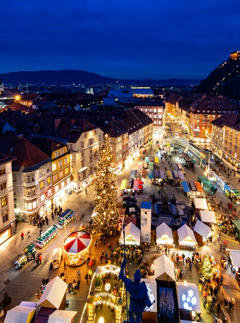 Evening Christmas market at Hauptplatz in Graz with Christmas tree and stalls. | © Graz Tourismus - Harry Schiffer