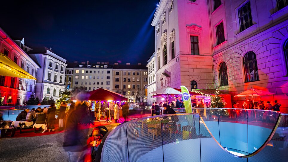 Various stalls and festive lights in Graz's Joanneum quarter, surrounded by historic buildings and a lively atmosphere. | © Graz Tourismus - Werner Krug