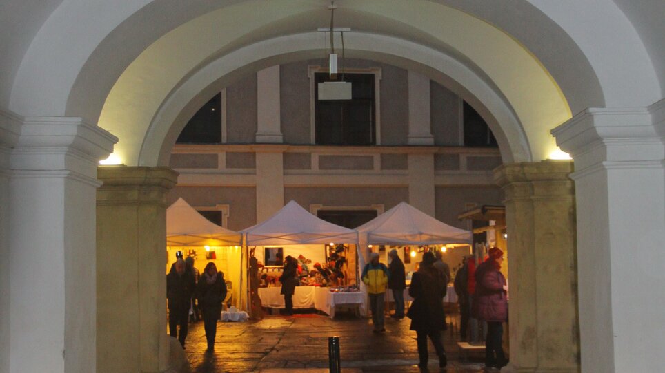 Entrance to the Joanneum quarter with Christmas stalls and visitors. | © Steirische Initiative Kunsthandwerk - Hans Waltersdorfer