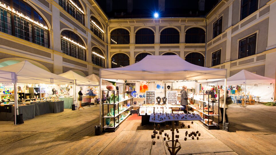 Christmas market in the Joanneum quarter, featuring lit stalls and decorations. | © Graz Tourismus - Harry Schiffer