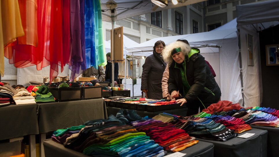 Market stalls with colorful scarves and fabrics in Graz during the Advent season. | © Steirische Initiative Kunsthandwerk - Nandor Vidakovich