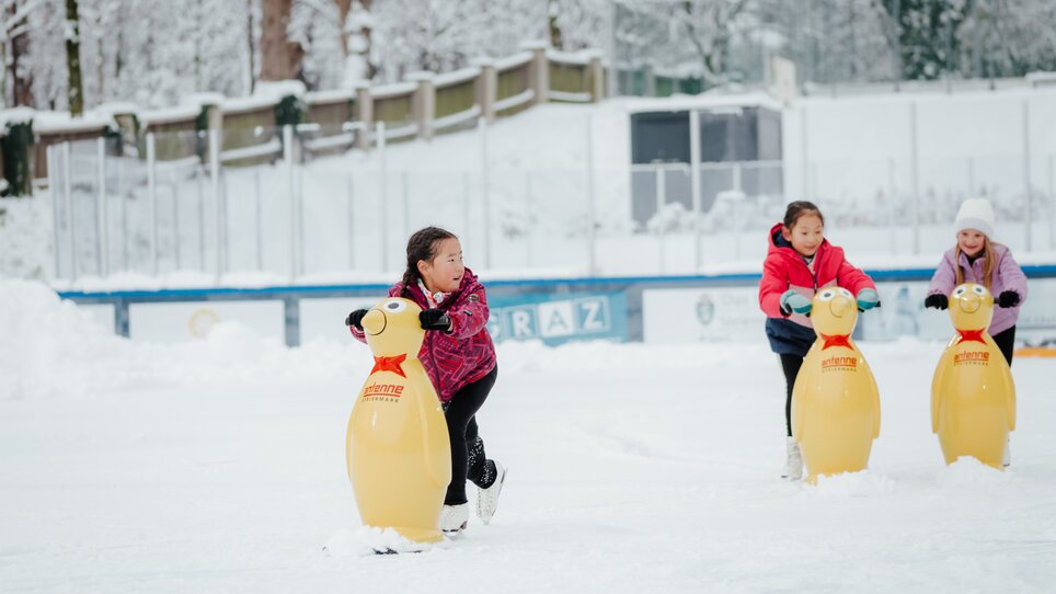 Kinder auf dem Eislaufplatz ziehen mit Pinguin-Hilfen über das Eis. | © Daniel Kindler