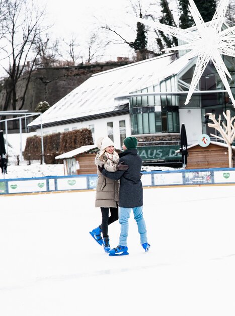 Two people ice skating on a wintery rink in Graz. | © Graz Tourismus - Mias Photoart