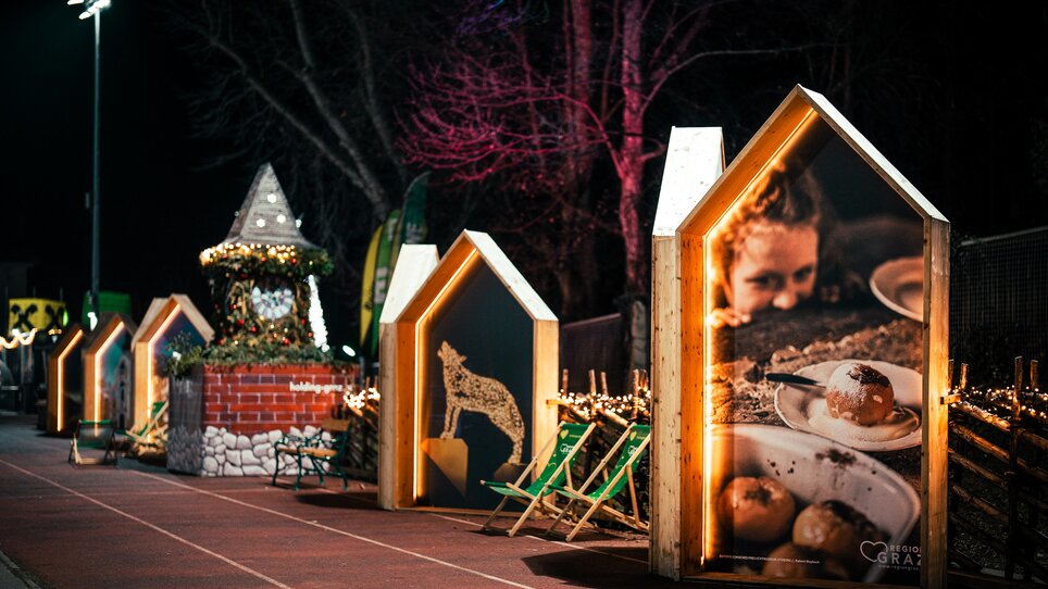 Beleuchtete Holzrahmen in der Form von Häusern mit Bildern der Region Graz bei der Grazer Winterwelt. | © Kuro Simon