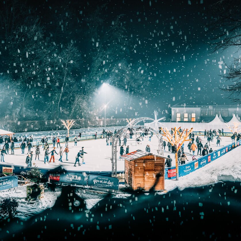 Winterliche Stimmung auf dem Eislaufplatz in Graz, mit vielen Schlittschuhläufern und festlicher Beleuchtung. | © Stefan Leitner