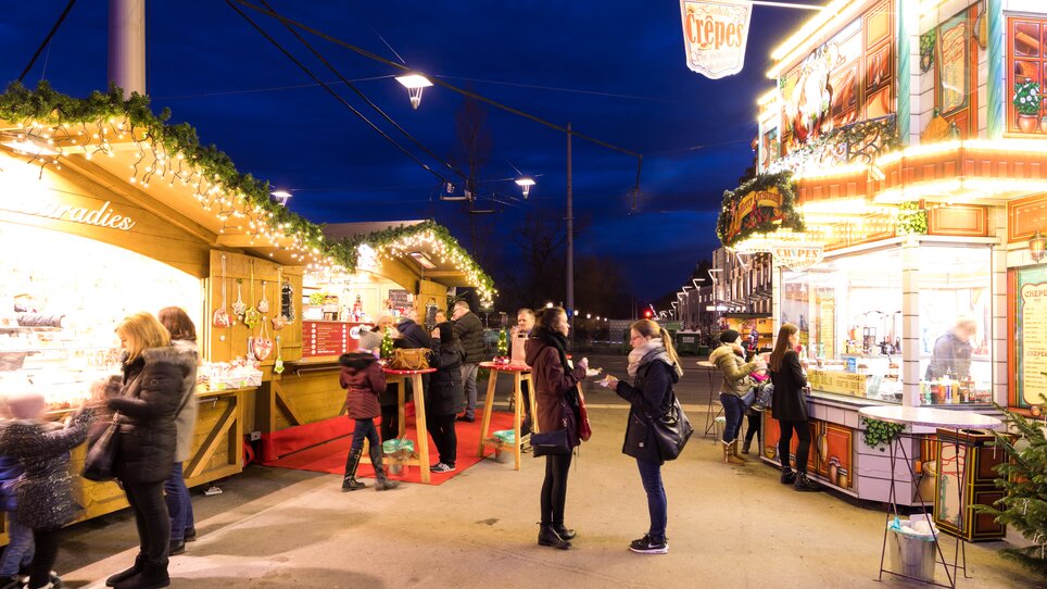 Illuminated Advent stalls in Graz with people and festive atmosphere. | © Graz Tourismus-Harry Schiffer