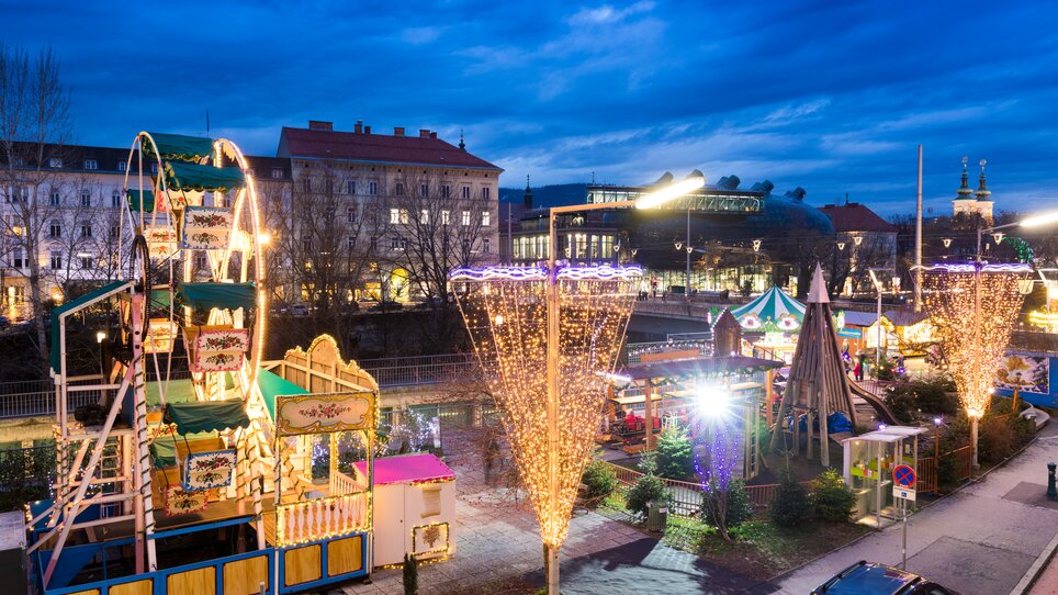 Illuminated rides and stalls at the Advent market in Graz. | © Graz Tourismus-Harry Schiffer