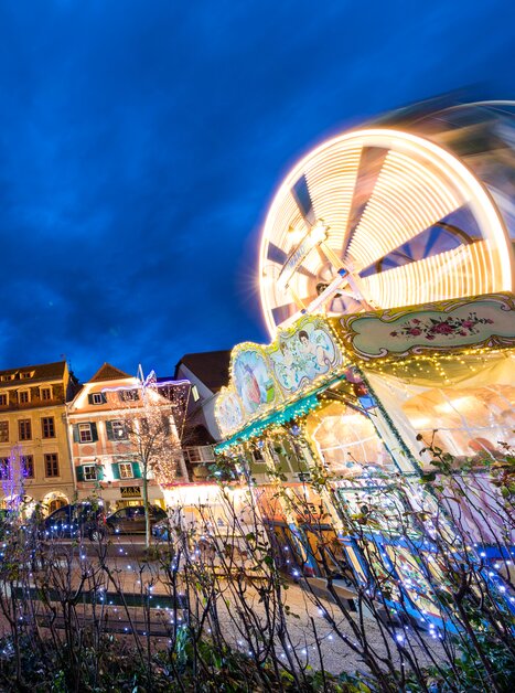 Beleuchtete Stadt mit Turm und Fahrgeschäften zur Adventszeit. | © Graz Tourismus-Harry Schiffer