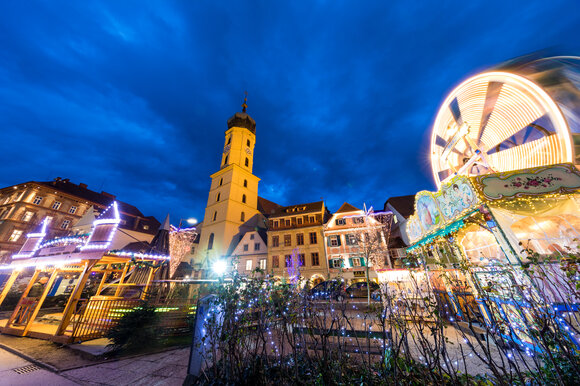 Beleuchtete Stadt mit Turm und Fahrgeschäften zur Adventszeit. | © Graz Tourismus-Harry Schiffer