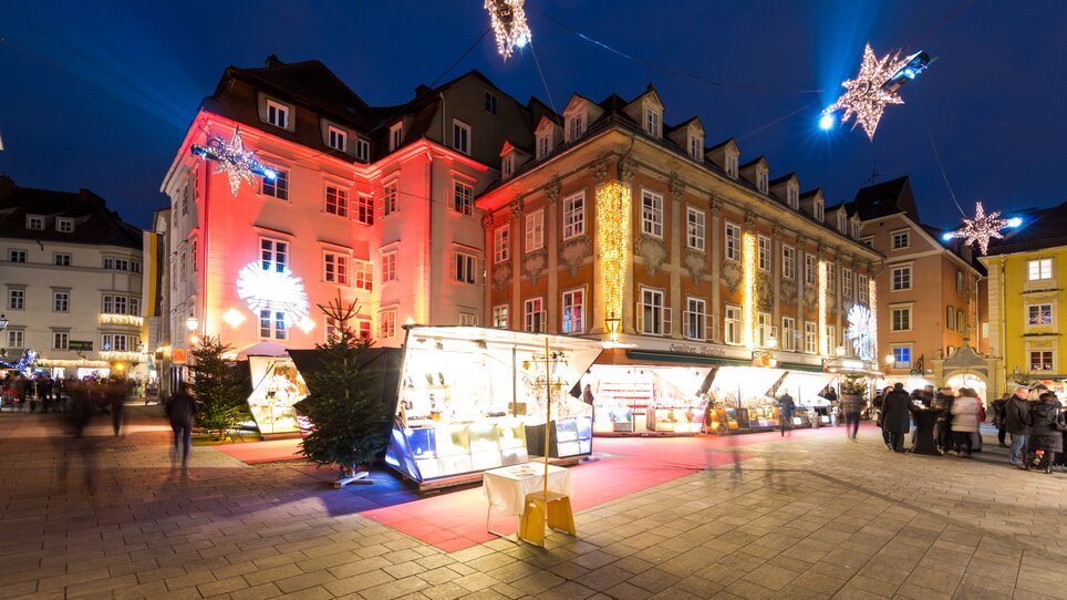 Illuminated buildings and stalls at the Christmas market in Graz, festive decorations. | © Graz Tourismus - Harry Schiffer