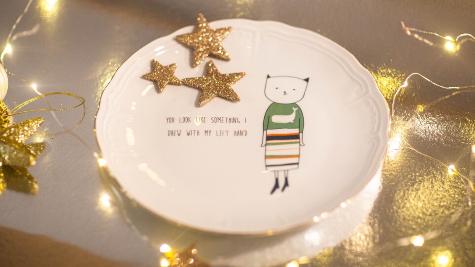 A plate featuring a drawing of a cat and the text: 'You look like something I drew with my left hand.' | © Evgenia Rieger Photography