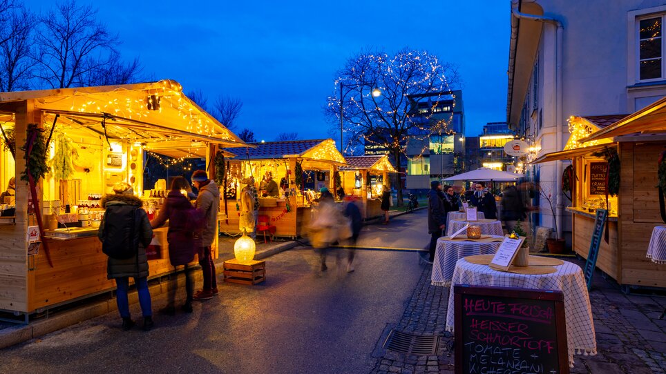 Beleuchtete Stände und Besucher auf dem Grieskindlmarkt in Graz bei Dämmerung. | © Graz Tourismus - Harry Schiffer