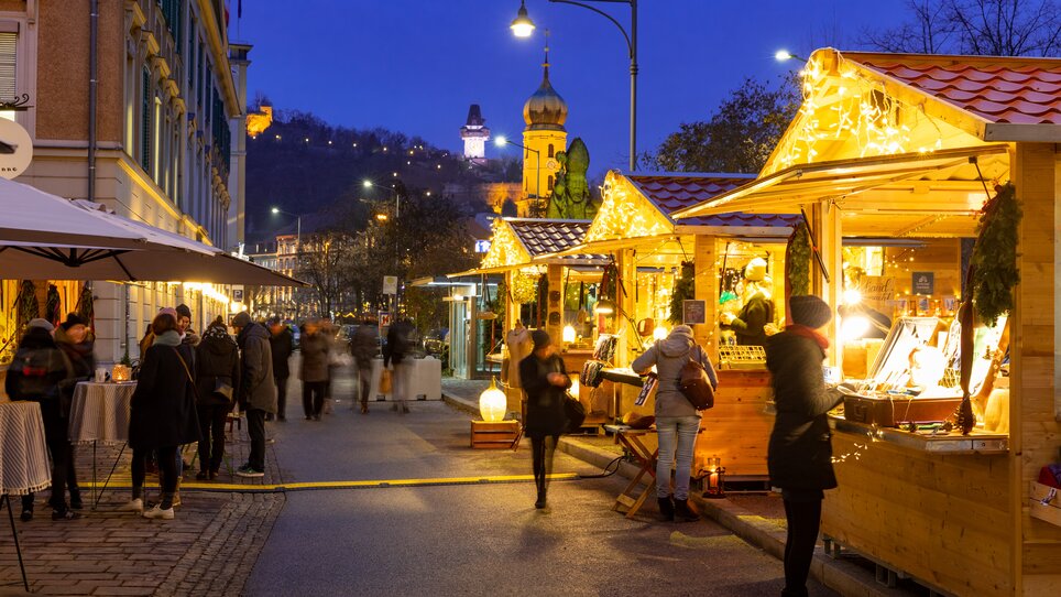 Beleuchtete Stände auf dem Weihnachtsmarkt in Graz bei Nacht. | © Graz Tourismus - Harry Schiffer