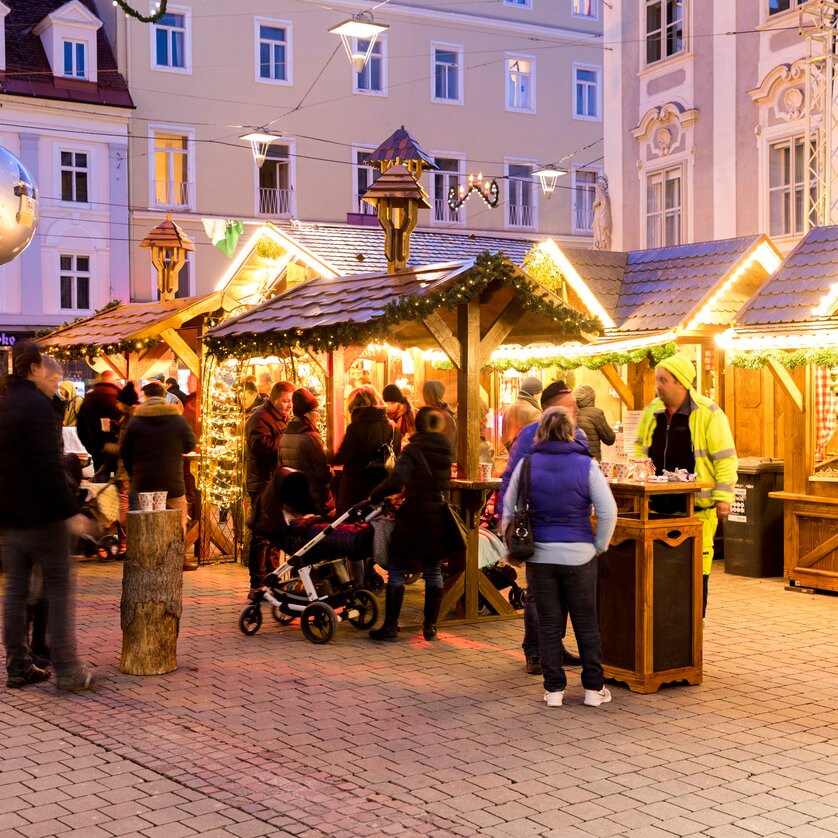 Advent in Graz I Christkindlmarkt am Südtiroler Platz | © Graz Tourismus - Harry Schiffer Belebte Szene am Christkindlmarkt in Graz mit festlich dekorierten Holzständen und Besuchern. | © Graz Tourismus - Harry Schiffer