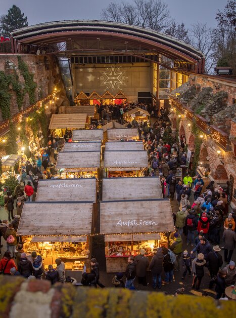 The Christmas market on Schlossberg hill in Graz, full of lights and people exploring the various stalls. | © ivents