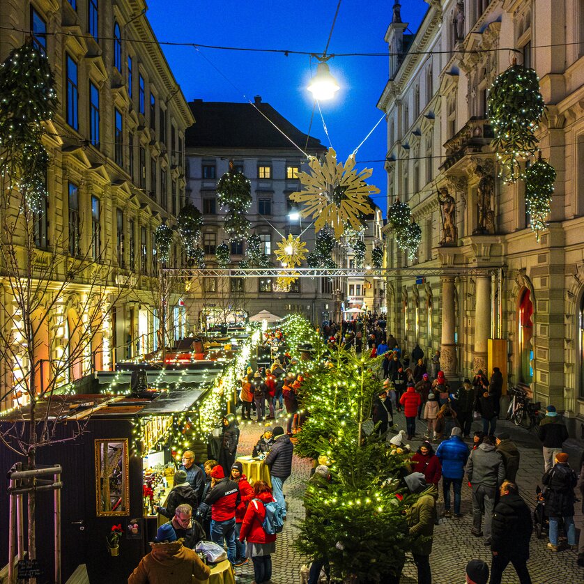 Advent in Graz I Adventlounge Schmiedgasse | © Rene Walter Beleuchtete Adventstände und Weihnachtsmarkt in der Schmiedgasse, Graz, festlicher Abend mit vielen Besuchern. | © Rene Walter