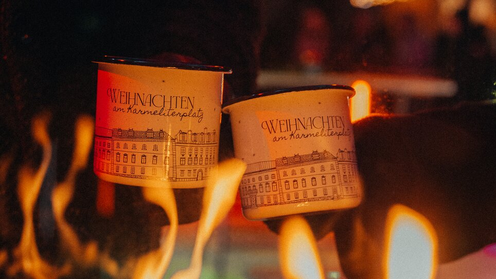 Two mulled wine mugs above flaming wood fire at Karmeliterplatz. | © Mias Photoart